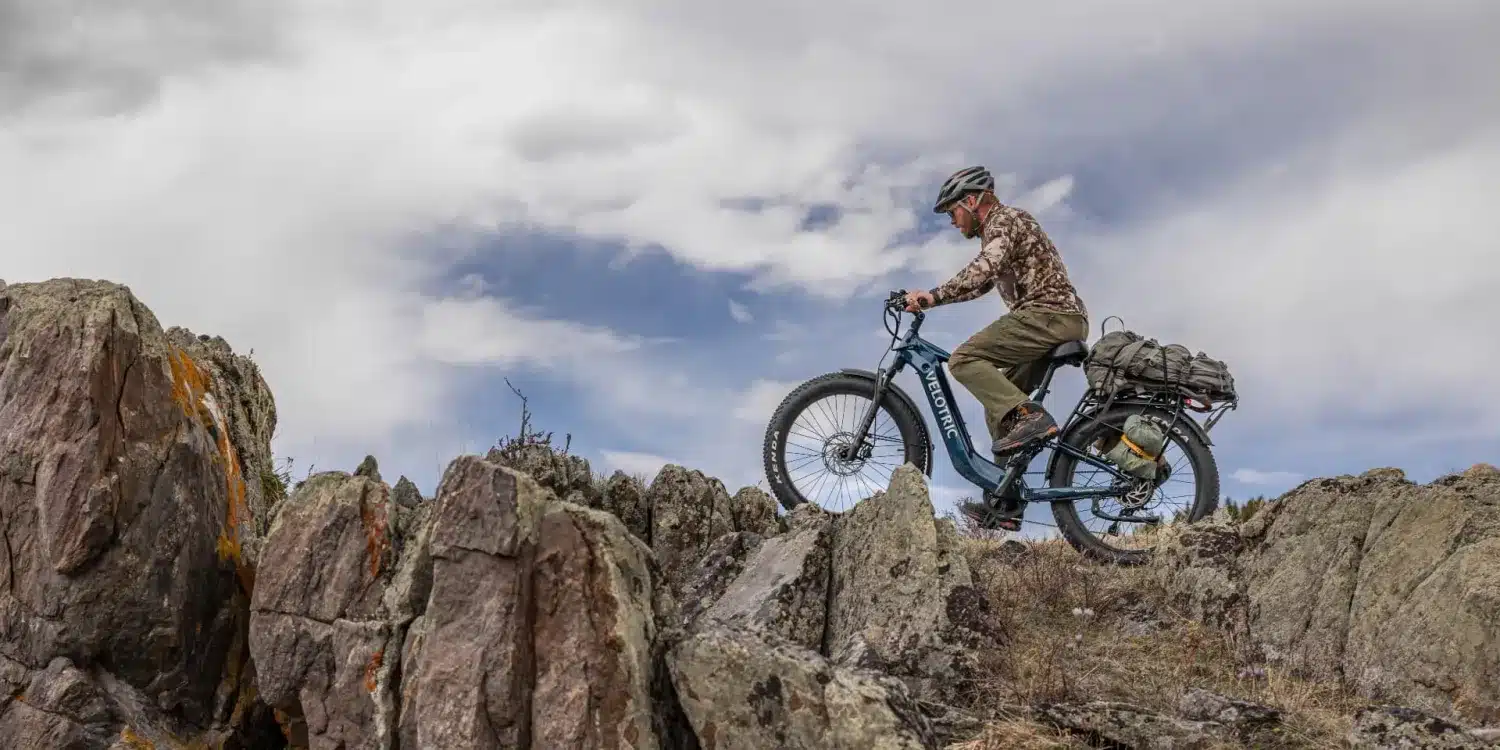 The Best Electric Mountain Bikes You Can Buy Online 16 Rider climbing a rocky trail on a Velotric Nomad 2X full suspension fat tire electric bike