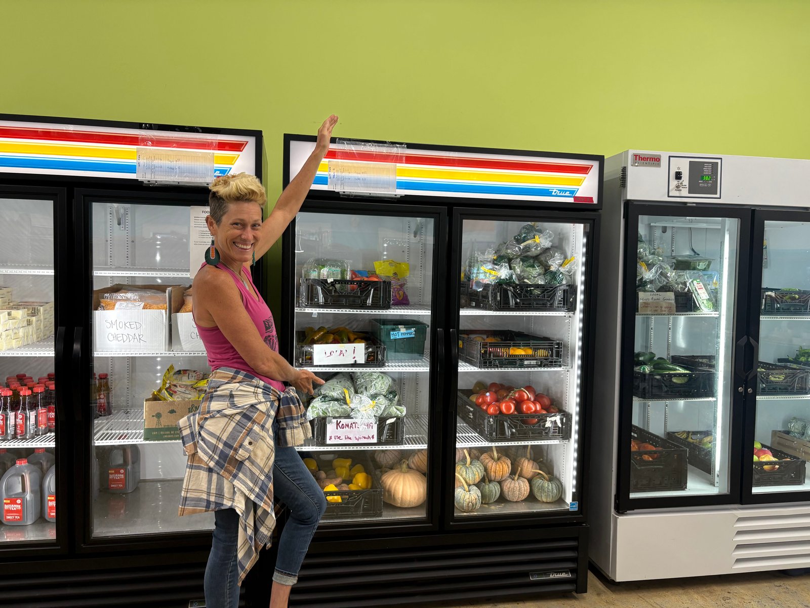 A woman gestures at a freezer section