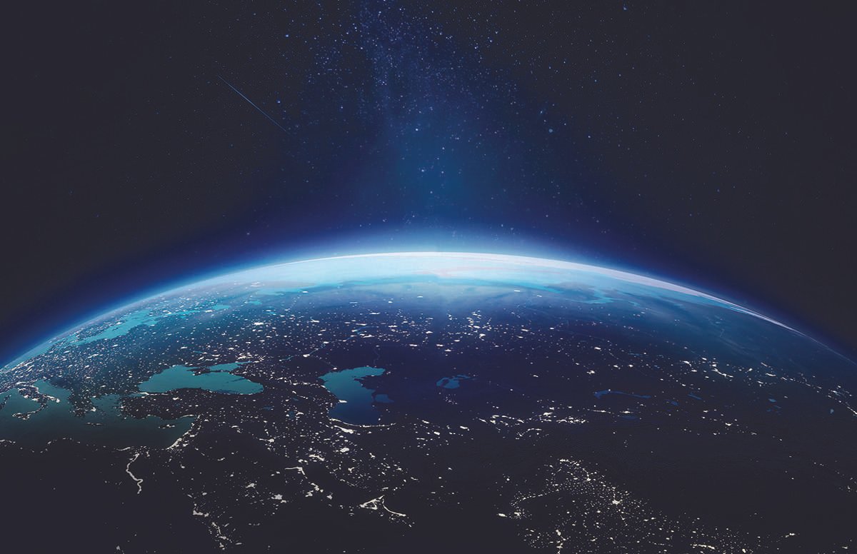 Image of the Earth from space, with light breaking on the edge of the globe from behind it