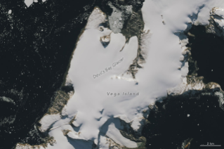 Part of an ice-covered Antarctic island has the appearance of a grinning skull in profile, with a rock outcrop as an eye socket and lateral moraine as a mouth.